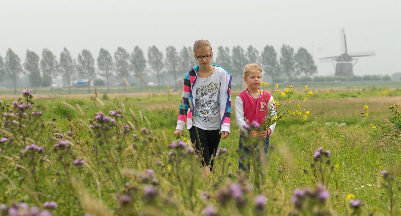 kinderen struinen door de bloemrijke Oostvlietpolder